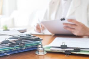 Einsicht in die Patientenakte: Behandlungsunterlagen und Stethoskop auf einem Schreibtisch