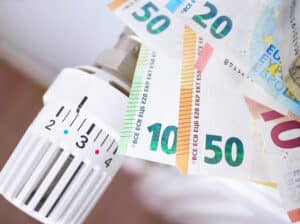 Heizkörperthermostat mit Euroscheinen als Symbol für Heiz- und Betriebskosten